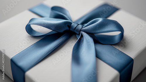 White gift box with a blue ribbon on a gray background.