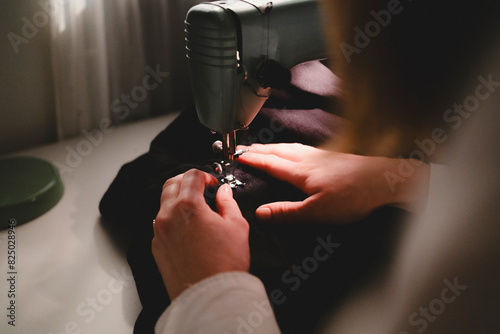 Cropped image of woman sewing fabric in machine photo