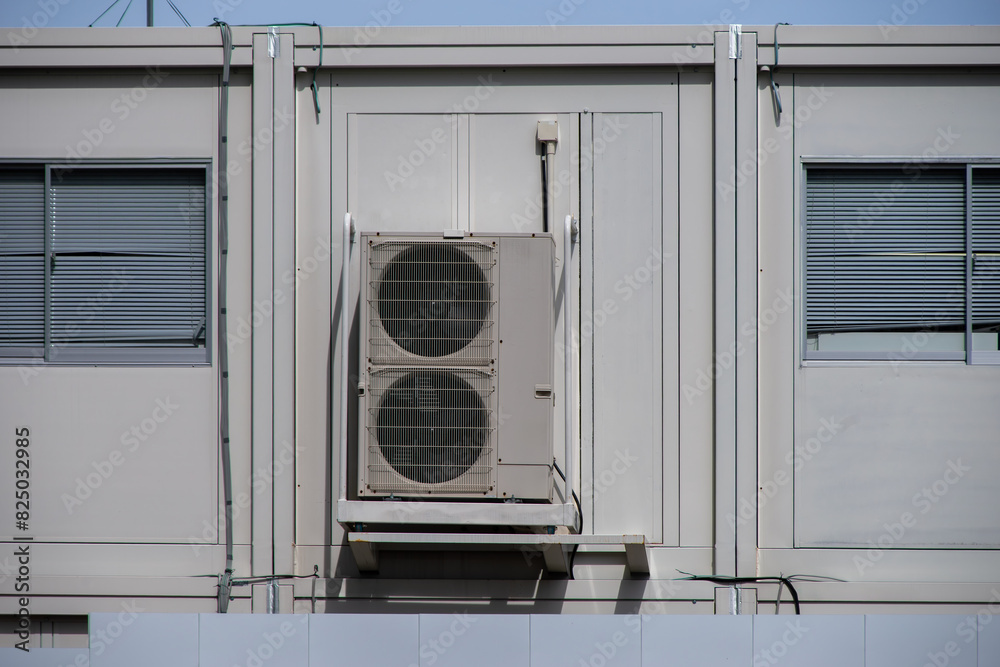 壁面に取り付けられたエアコンの室外機 壁面に取り付けられたエアコンの室外機