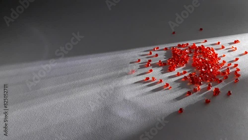 Transparent red polycarbonate masterbatch granules poured over a white background with dramatic light lines, this polymer is a colorant for products in the plastics industry photo