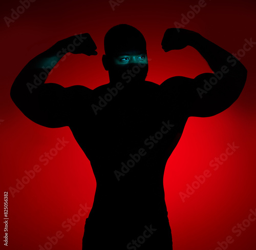 Shadow, muscle and man flexing, fitness and challenge for wellness on red studio background. Person, model and bodybuilder with endurance, exercise and silhouette with health, strong and workout
