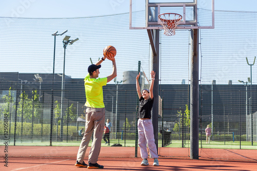 father and daughter playing basketball together on playground © Angelov