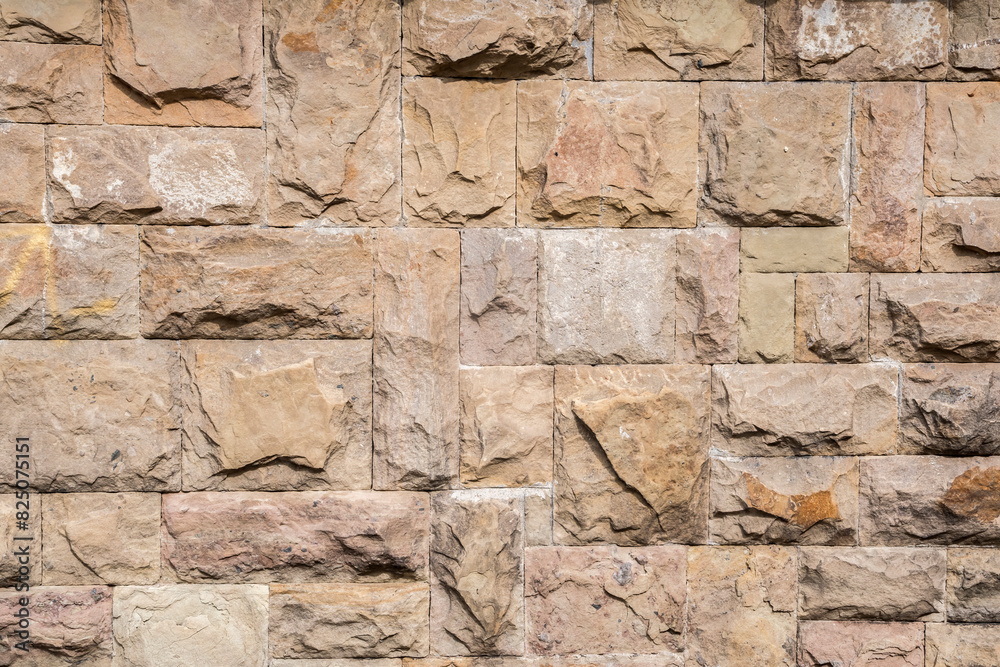 Solid house stone wall of roughly hewn stone closeup as stone background