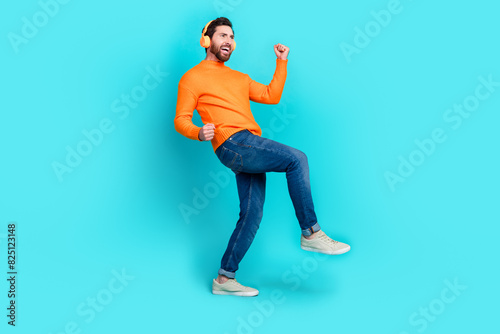 Photo of crazy meloman funny man wear trendy clothes listen music look empty space isolated on cyan color background photo