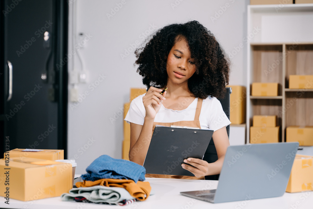 Startup small business SME, Entrepreneur owner woman using smartphone or tablet taking receive and checking online purchase shopping order Startup small business SME, Entrepreneur owner woman using smartphone or tablet taking receive and checking online purchase shopping order