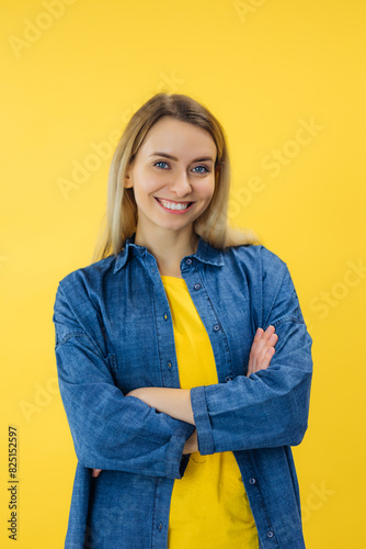 woman with crossed hands isolated on vibrant yellow color background, vertical