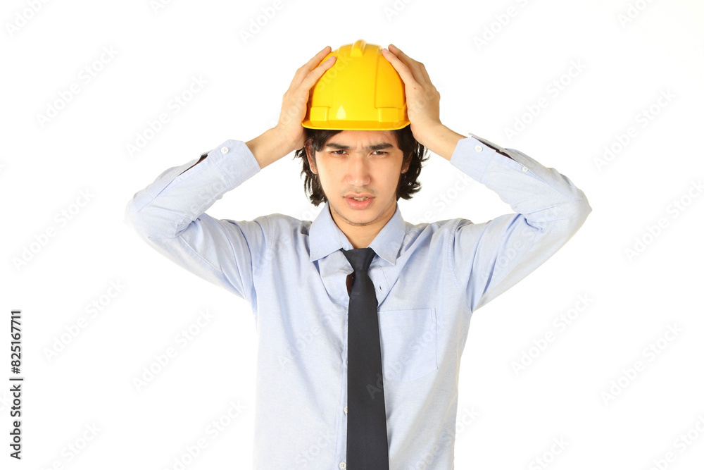 A young engineer wearing a yellow safety helmet with a headache on white background A young engineer wearing a yellow safety helmet with a headache on white background