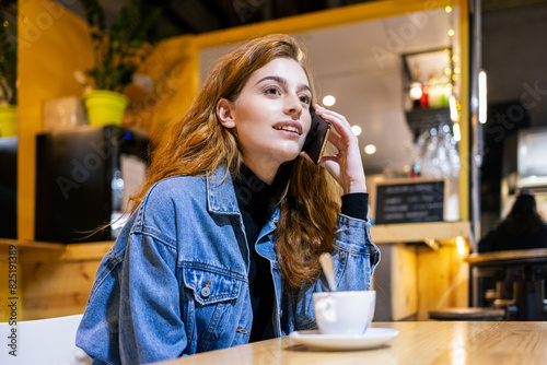 Young red-haired girl talking on her cell phone photo