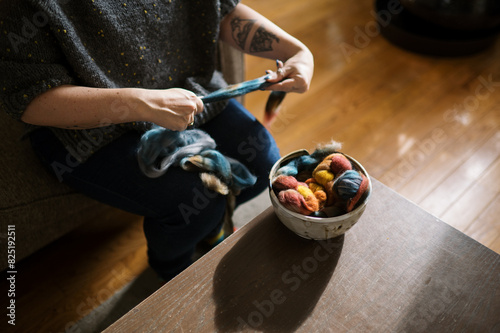 woman prepping colorful roving fiber for spinning photo