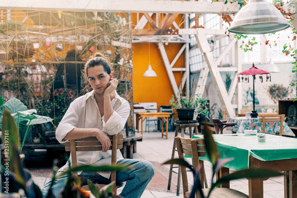 Portrait of a man sitting in glasshouse Portrait of a man sitting in glasshouse