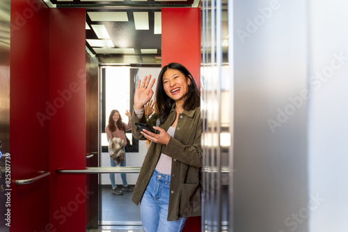 Woman inside elevator using phone photo
