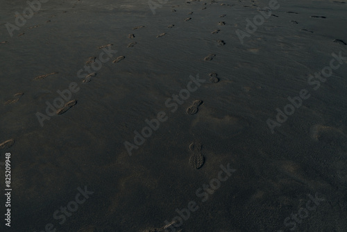 Man footprints on Black sand beach