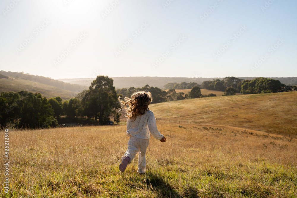 Little girl running in the middle of a grass field Little girl running in the middle of a grass field