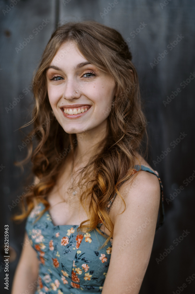 smiling teenage girl in front of wooden barn smiling teenage girl in front of wooden barn