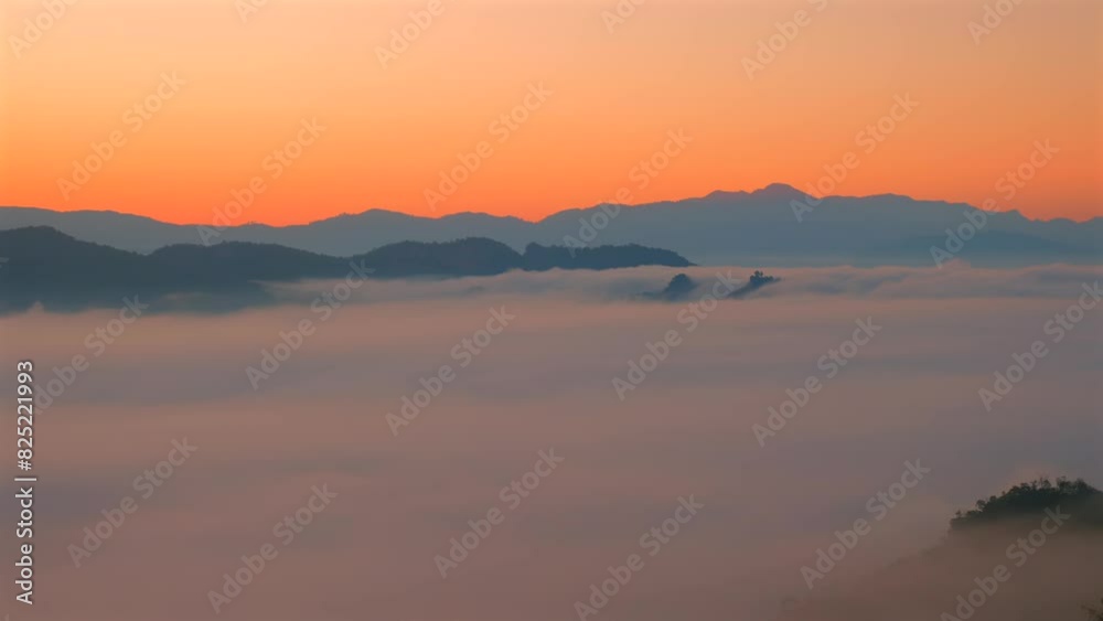 Serene sunrise panorama with mountains and sea of clouds. Beautiful gradient sky with subtle orange and pink hues that reflect calm and peace of early morning. Serene sunrise panorama with mountains and sea of clouds. Beautiful gradient sky with subtle orange and pink hues that reflect calm and peace of early morning.