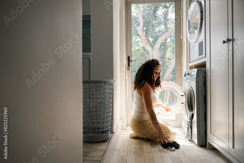 Woman washing clothes in laundry room photo
