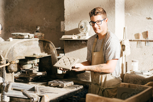 Photography Young Man Displaying Hydraulic Tile With Barcelona Panot Design in Artisan Works
