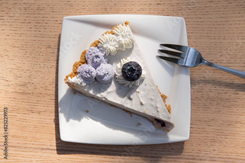 Slice of pie under afternoon sunlight on table.