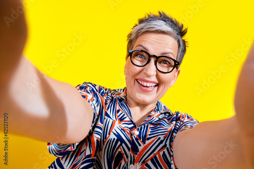 Photo of nice aged lady take selfie record video wear shirt isolated on yellow color background