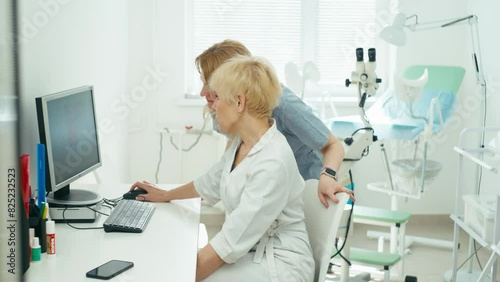 Two doctors read the patient's history on the computer. A meeting is held in the gynecologist's office. High quality 4k footage photo