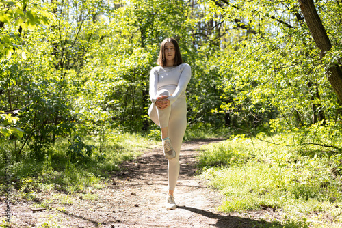 sport outdoors, young woman tights her knee up to her chest