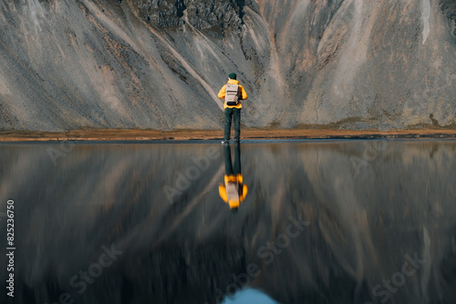 Man Reflection In Ocean Water. Mountain on Background.
 photo