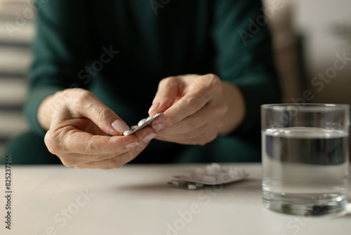 Woman taking pills / drugs at home photo