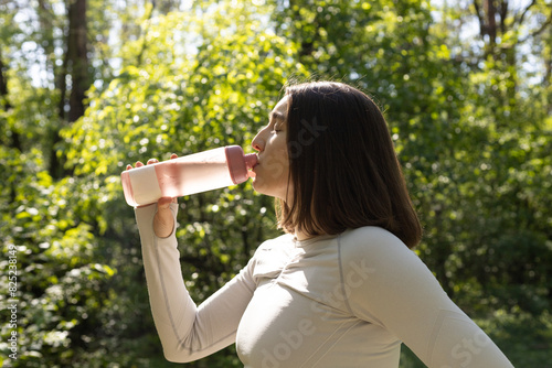 Tableau sur toile young woman drinks water from a bottle during exercise