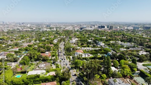 Beverly Hills Aerial 2024 - Flying high to low between palm trees and road 