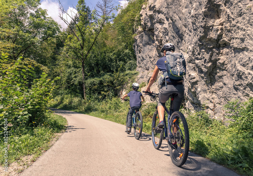 Mother and young son riding bikes along a scenic rural landscape. Outdoors family activity concept.