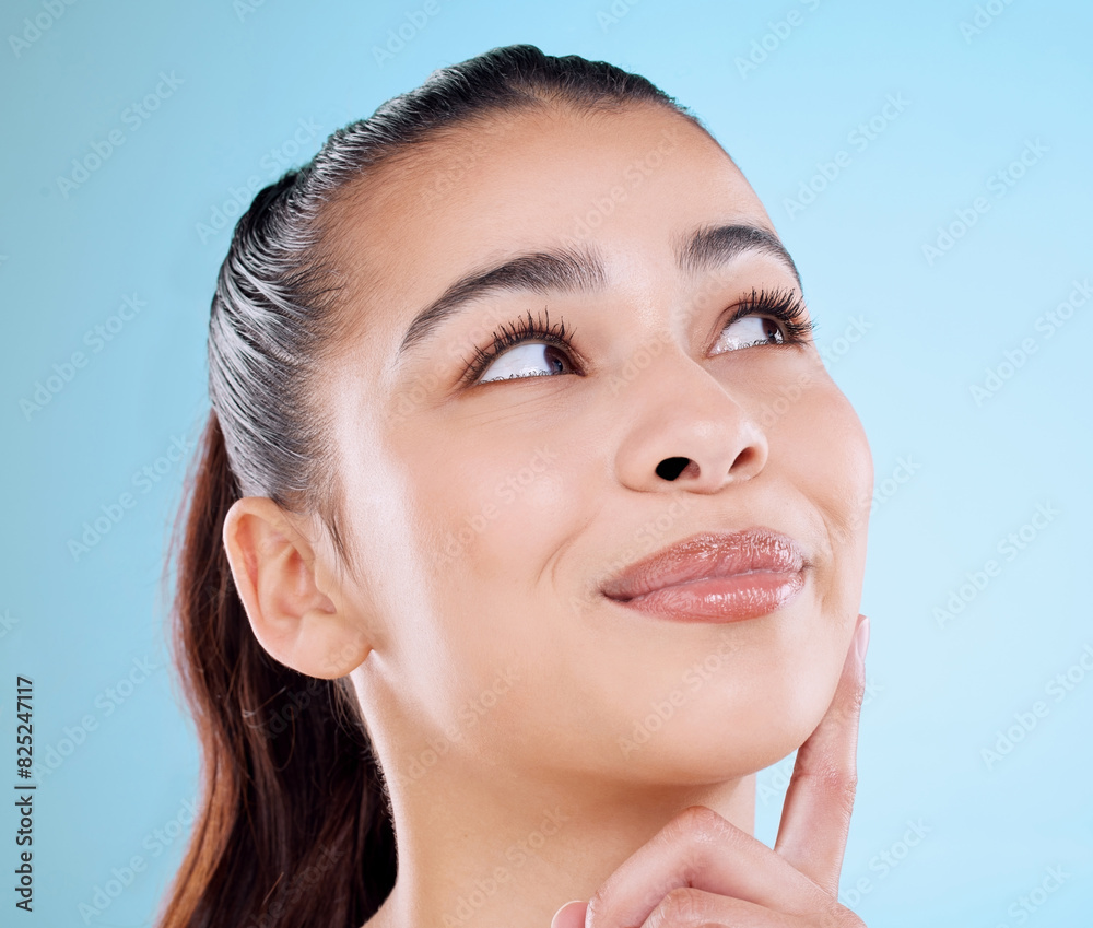 Skincare, smile and woman with thinking in studio for dermatology, treatment and idea for self care. Happy, female person and face with shine for cosmetics, glow and satisfaction on blue background