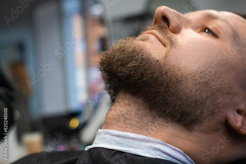 A man is waiting to cut a beard in the barbershop. 