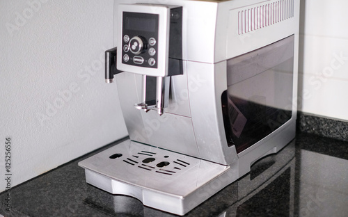 A silver coffee maker with a digital display sits on a counter