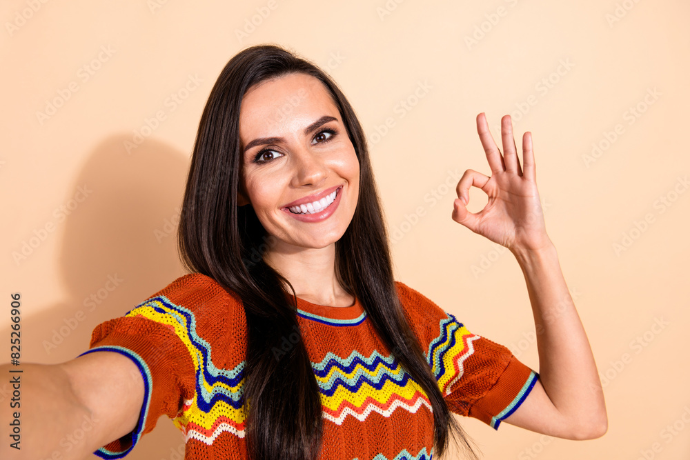 Photo of nice young woman make selfie show okey symbol wear t-shirt isolated on beige color background Photo of nice young woman make selfie show okey symbol wear t-shirt isolated on beige color background