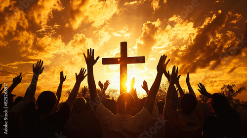 Group of crowd of Christians raise their hands in the air worshiping the cross. Religion concept of faith and prayer with bright sunset photo