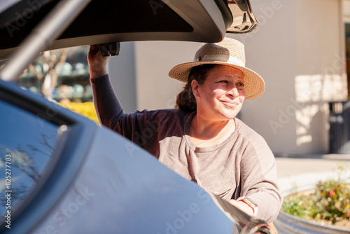 Woman closing car trunk photo