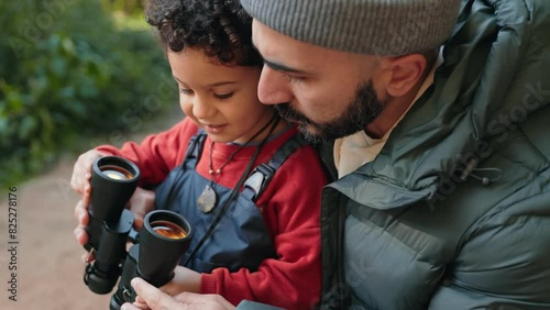 A heartwarming scene of a father teaching his son to use binoculars during an outdoor adventure, showcasing familial bonding and curiosity in nature. photo