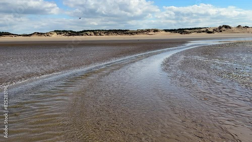 Water streaming back to the sea during low tide, Irish sea coast, Merseyside, North West of England. photo