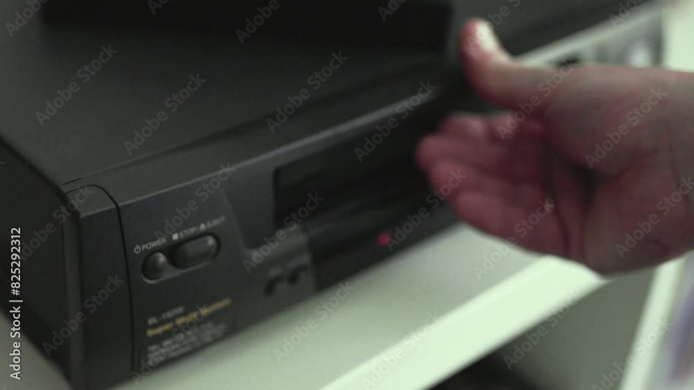Close up of a hand holding a videotape. Retro vhs cassete in a player. Close up of a hand holding a videotape. Retro vhs cassete in a player.