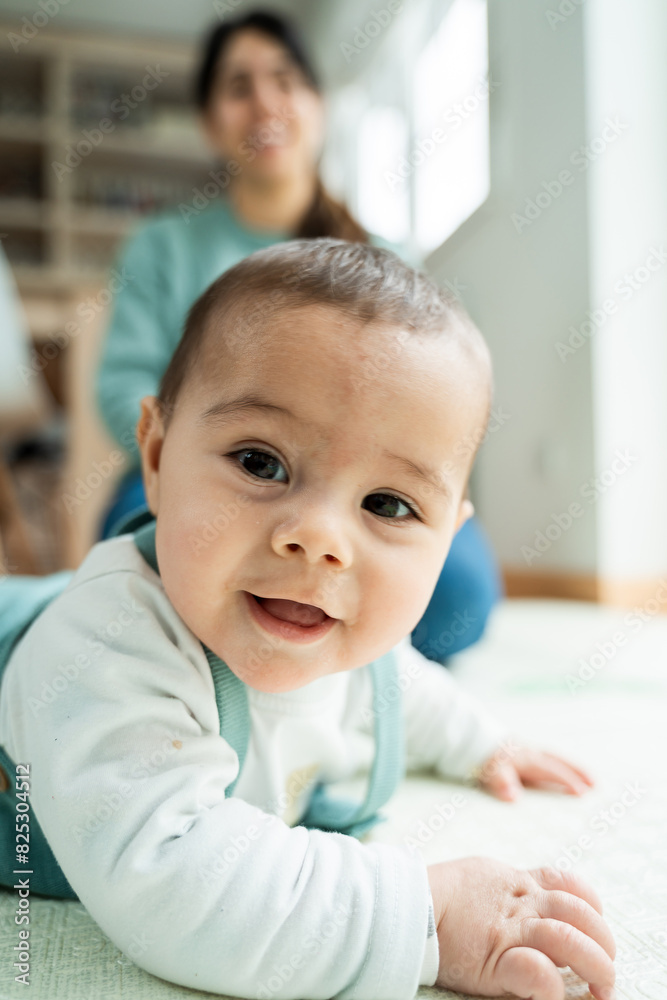 Joyful baby with mother in background Joyful baby with mother in background