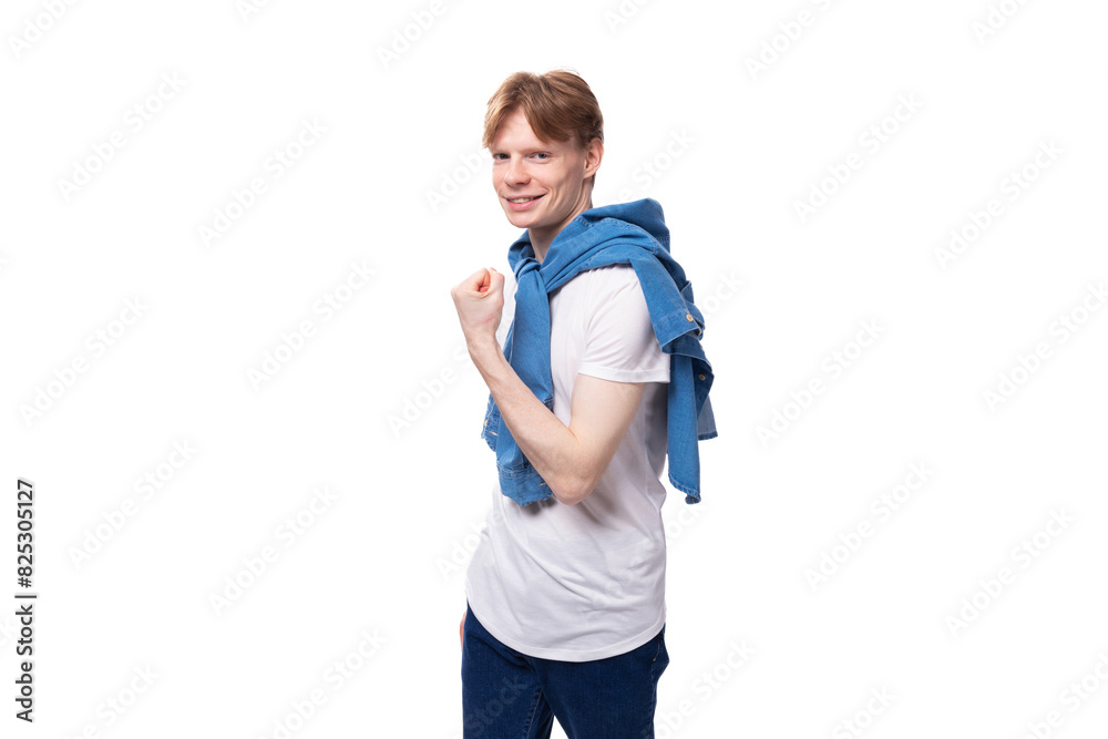 young well-groomed cute caucasian male student with golden red hair with a tattoo on his arms is dressed in a white t-shirt young well-groomed cute caucasian male student with golden red hair with a tattoo on his arms is dressed in a white t-shirt