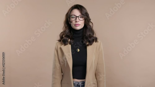 Gossiper business woman with finger on lips - shh, secret, silence, beige studio photo