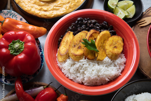 Black beans stew stu with fried plantains banana Buffet table full of lunch assorted dishes Peru Peruvian food photo