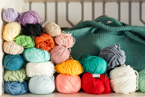 Colorful assortment of yarn balls with knitting bag photo