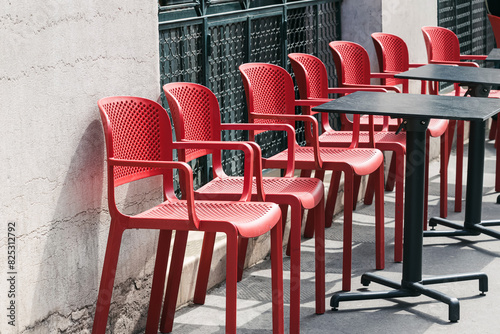 Red chairs of the small cafe in a row at the street of Paris