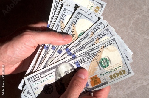Counting a pile of hundred dollar bills closeup