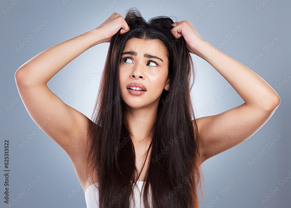 Frustrated woman, hair and damage with disaster for bad day, treatment or haircut on a blue studio background. Upset female person or young model with stress, dry or bristle piece for messy scalp Frustrated woman, hair and damage with disaster for bad day, treatment or haircut on a blue studio background. Upset female person or young model with stress, dry or bristle piece for messy scalp