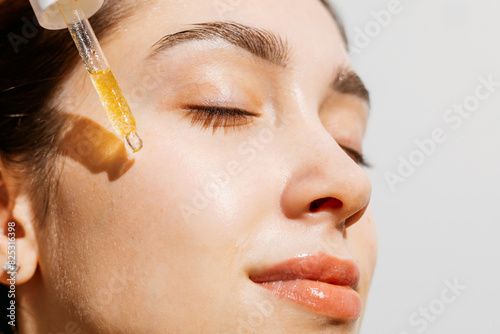 A woman Serum Application on Radiant Skin.  Skincare routine  photo