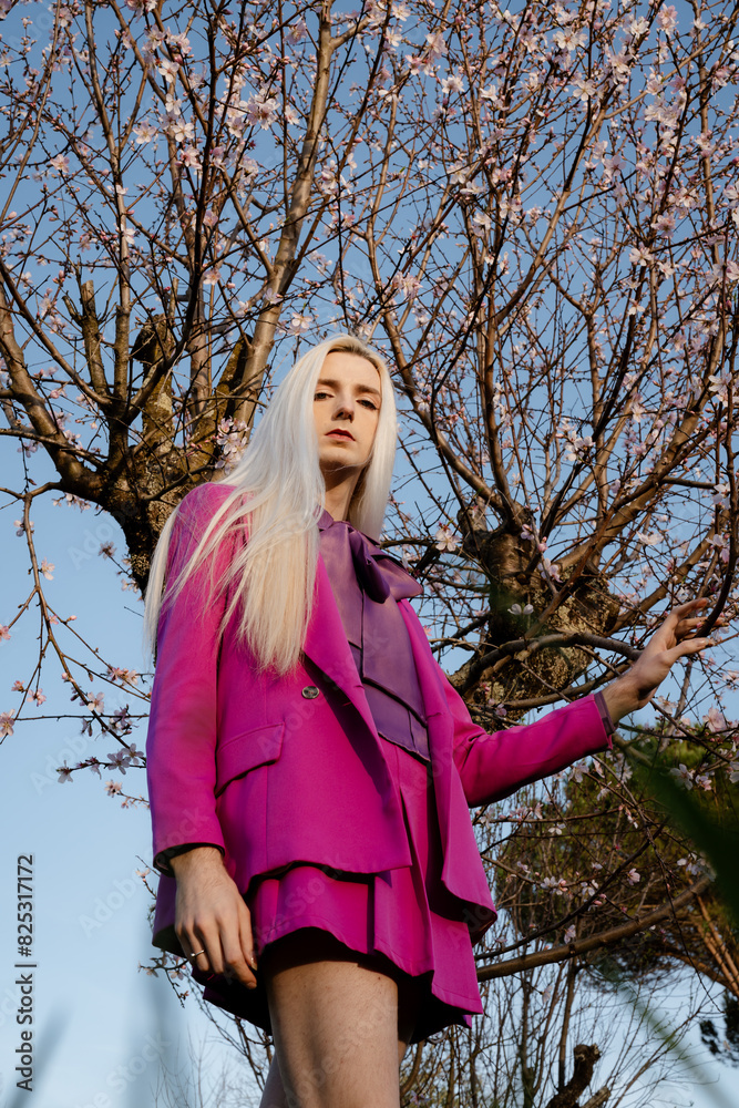 A blond man in pink clothes in a flowered garden A blond man in pink clothes in a flowered garden