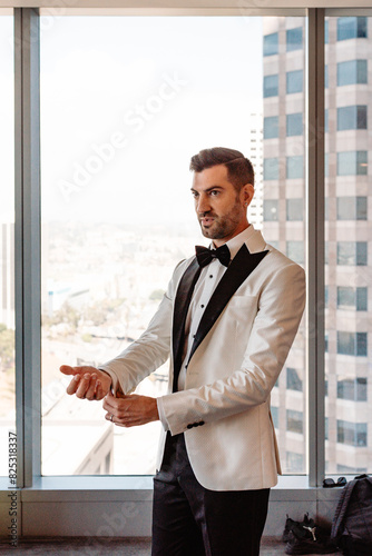 Gay Groom adjusting his tuxedo cuffs photo